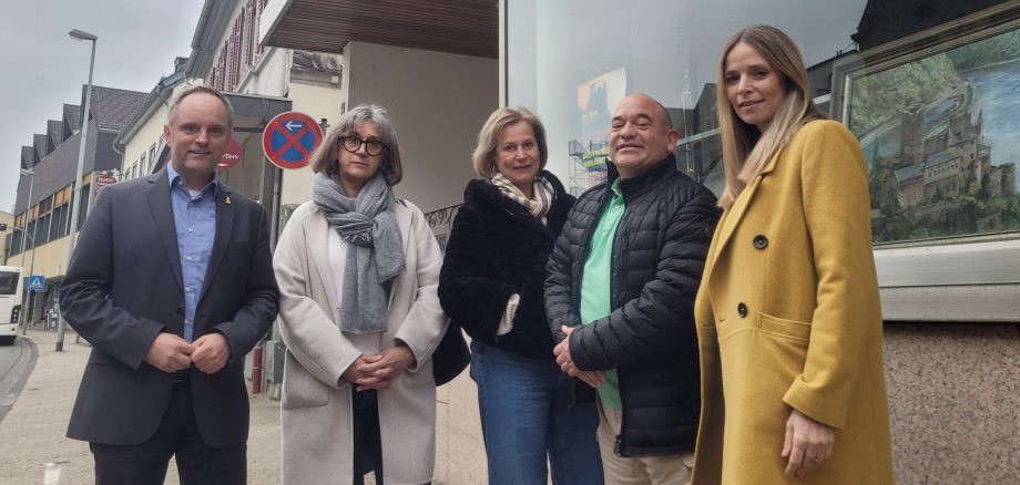 Bürgermeister Mike Weiland, Dr. Manuel Molitor mit seinem Team und Melitta Fechner von der kassenärztlichen Vereinigung Rheinland-Pfalz stehen vor dem Gebäude, wo zukünftig die Arztpraxis einziehen soll.