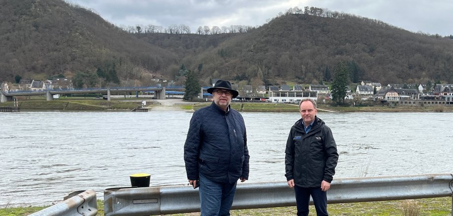 Bürgermeister der Verbandsgemeinde Loreley, Mike Weiland (rechts), und der Regionalgeschäftsführer der IHK Koblenz, Richard Hover (links), am geplanten Standort der Mittelrheinbrücke in St. Goarshausen-Wellmich.