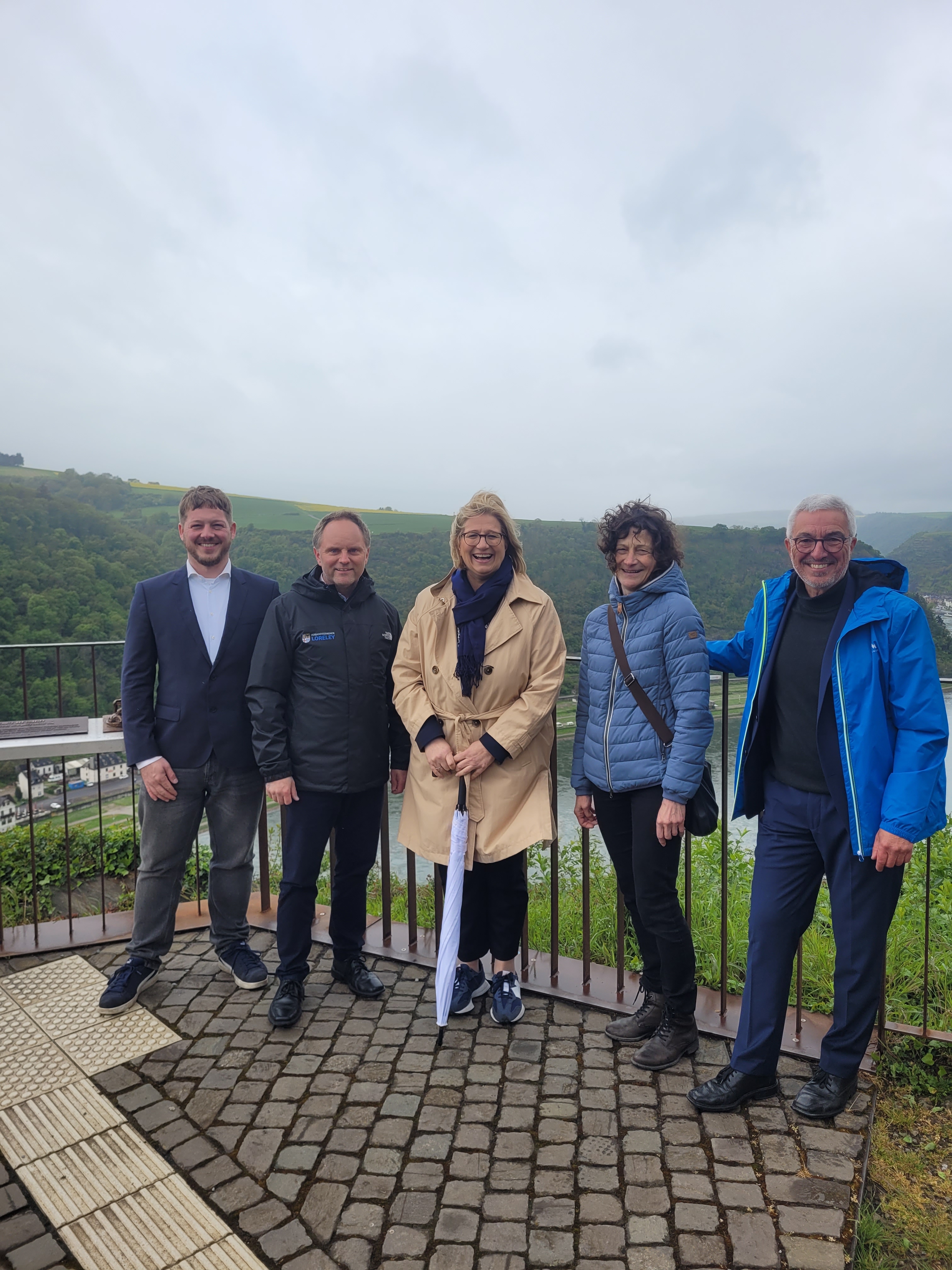 Für ein Gruppenfoto stehen von links nach rechts stehen St. Goarshausens Stadtbürgermeister Nico Busch, Bürgermeister Mike Weiland, Ministerpräsidentin des Saarlandes Anke Rehlinger, Bornichs Ortsbürgermeisterin Karin Kristja und Landtagsabgeordneter Roger Lewentz an der Loreleyspitze.