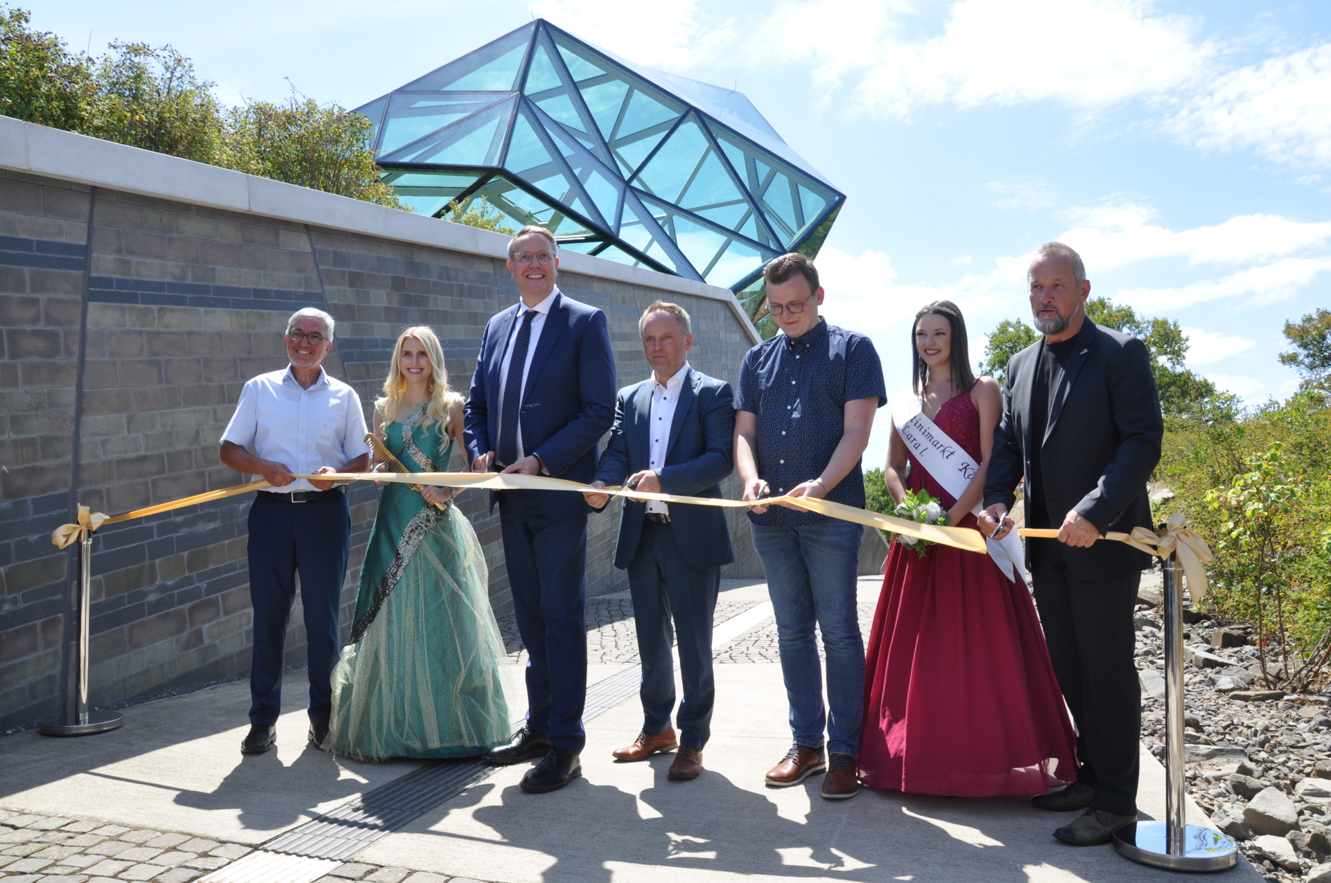 Ministerpräsident Alexander Schweitzer, Bürgermeister Mike Weiland und „Loreley“ Katharina Blanckart durschneiden das Eröffnungsband