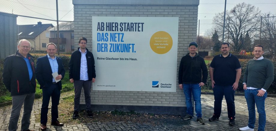 Vertreter der Ortsgemeinde Weisel, der Deutschen Glasfaser und der Verbandsgemeinde Loreley stehen vor dem PoP-Standort in Weisel